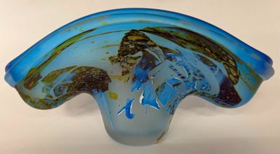 a blue glass vase with a wave design on it