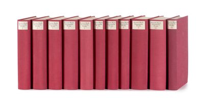 six livres rouges alignés sur une surface blanche