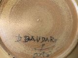 a brown plate with writing on it sitting on a table