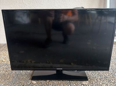 a flat screen tv sitting on top of a carpeted floor