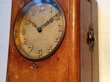 une horloge en bois accrochée au mur, sur laquelle figurent des chiffres