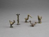 quatre figurines en bronze représentant des pélicans et des oiseaux sur un fond gris