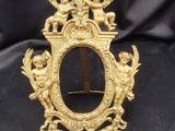 un cadre doré richement décoré, orné d'anges et de chérubins sur fond noir