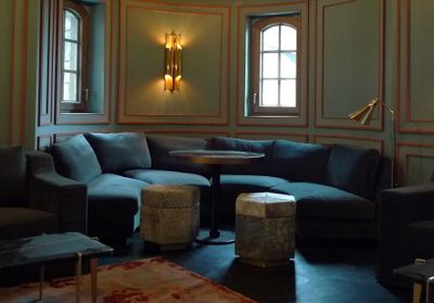 a living room with a couch, chair, ottoman, table and lamp