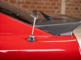 a close up of a red car with a chrome hood
