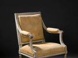 un fauteuil rembourré dont l'assise est recouverte de tissu beige