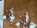 three wall sconces hanging on the wall next to a clock