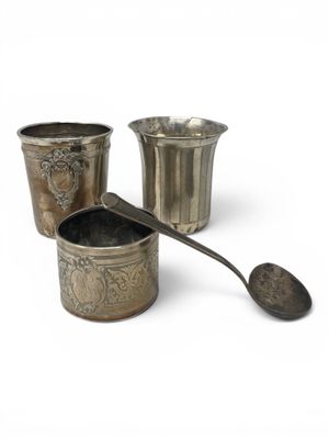 three cups and a spoon sitting next to each other