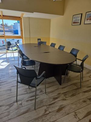 une grande table entourée de chaises dans une pièce