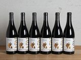 six bouteilles de vin sont alignées sur une table en bois
