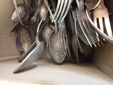 a lot of silver spoons and forks in a box