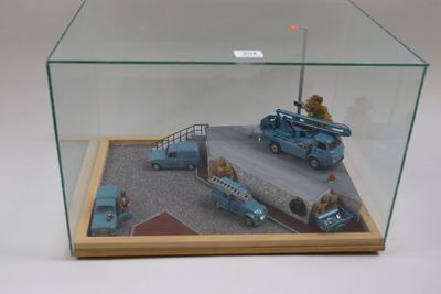 une vitrine en verre contenant un camion miniature et d'autres véhicules