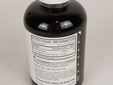 a bottle of black liquid sitting on a white surface
