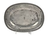 an old silver plate on a stand on a white surface