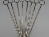 six pairs of antique scissors are arranged in a row on a table