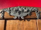 a silver vase with grapes on top of a wooden door