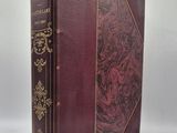 un vieux livre à la couverture rouge et à la bordure dorée