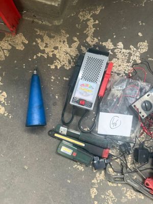 a lot of electrical equipment on the ground next to a blue cone