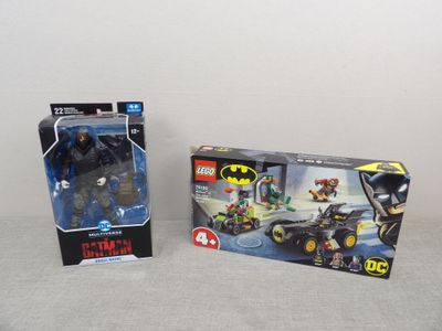 two lego batman figures are sitting next to each other on a table
