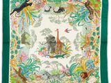 une écharpe verte ornée d'un motif représentant des animaux et des plantes