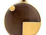 a close up of a brown and gold pendant on a white background