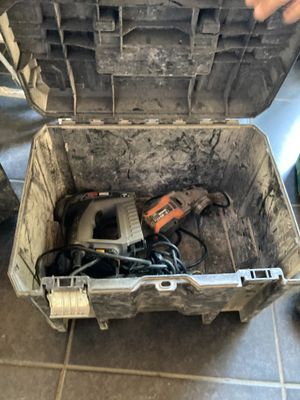 une boîte à outils contenant des outils, posée sur un sol carrelé