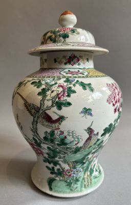 a white and green vase with a bird and flowers on it