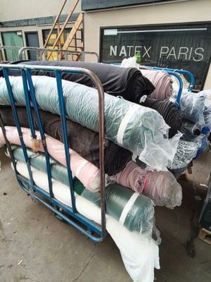 a lot of clothes on a cart outside of a building