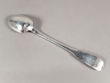une cuillère en argent avec un manche de cuillère sur une table