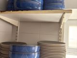 many plates and bowls on the shelves in the kitchen