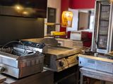 une grande cuisine avec de nombreux appareils électroménagers posés sur le plan de travail