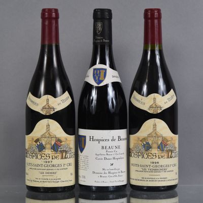 three bottles of red wine are lined up on a table