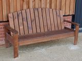 un banc en bois posé devant un mur de briques