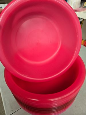 trois bols en plastique rouges empilés les uns sur les autres sur un plan de travail