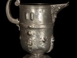 a silver cup with a handle on a black background