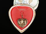 une boîte en forme de cœur contenant un pendentif en forme de cœur doré