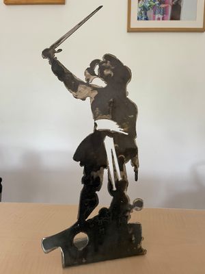 a statue of a man holding a sword on a table