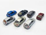several toy cars are lined up in a row on a white surface