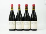 trois bouteilles de vin rouge sont alignées sur une surface blanche
