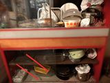 a red cabinet filled with dishes and utensils