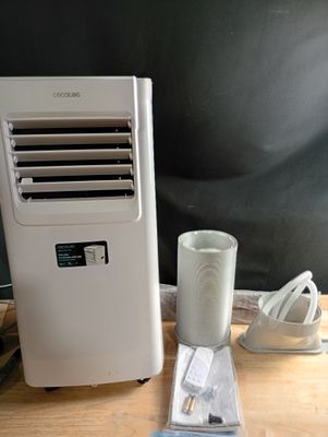 a small air conditioner sitting on a table next to a cup of coffee