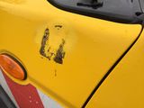 a close up of a yellow car with a sticker on it