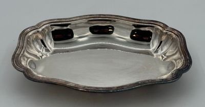 une assiette ancienne en argent sur laquelle figurent deux points noirs