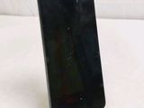 the back of a black cell phone sitting on top of a white surface