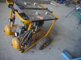 a yellow cart with a black table on it in a garage
