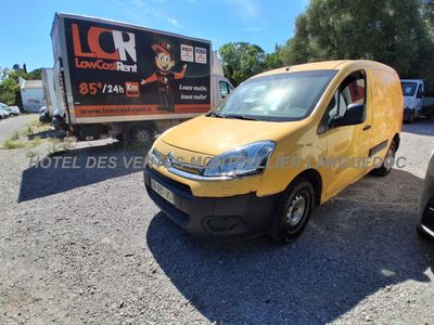 La camionnette jaune est garée sur le parking, à côté d'un camion.