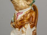 une figurine représentant un ours assis sur une chaise
