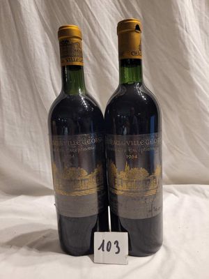 two bottles of red wine sitting on top of a white sheet
