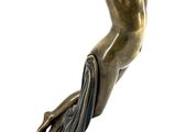 bronze statue of a woman holding a bowl on a rock
