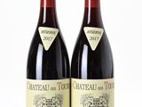 two bottles of red wine sitting next to each other on a white surface
